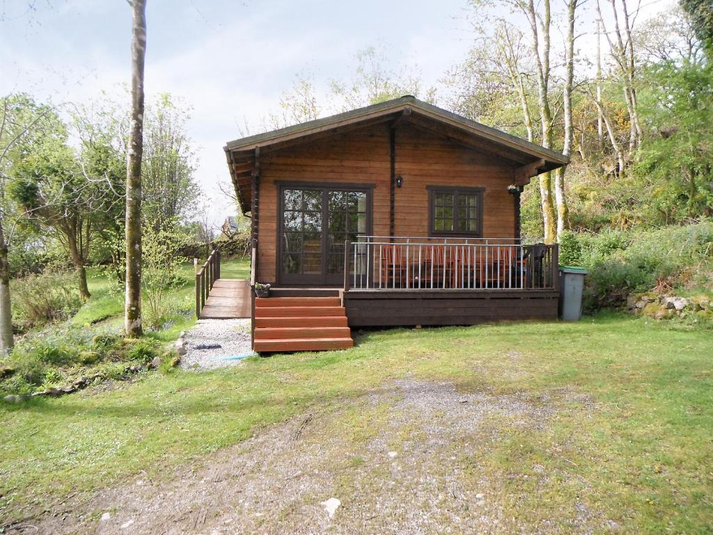 a log cabin with a porch and stairs in a yard at Auchenhill Lodge in Lochend