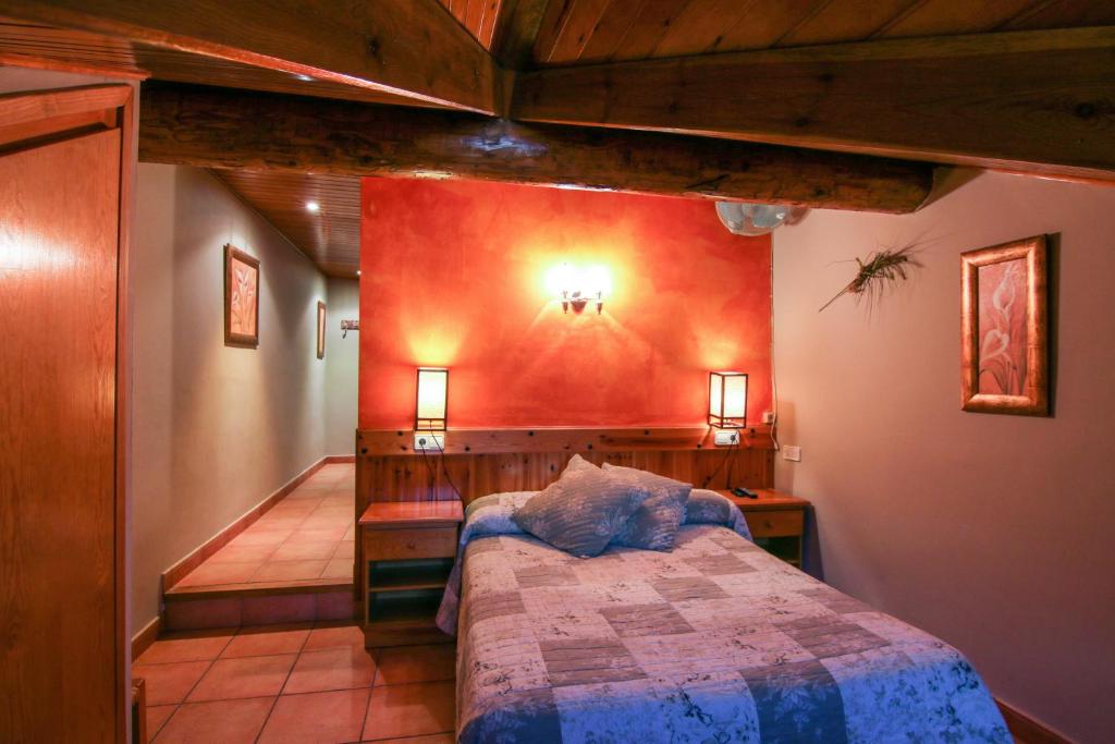 a bedroom with a bed and a red wall at Roch Hotel in Altrón