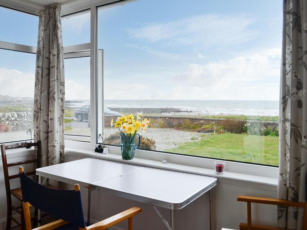 a window with a white table and a vase of flowers at Craignair in Port William