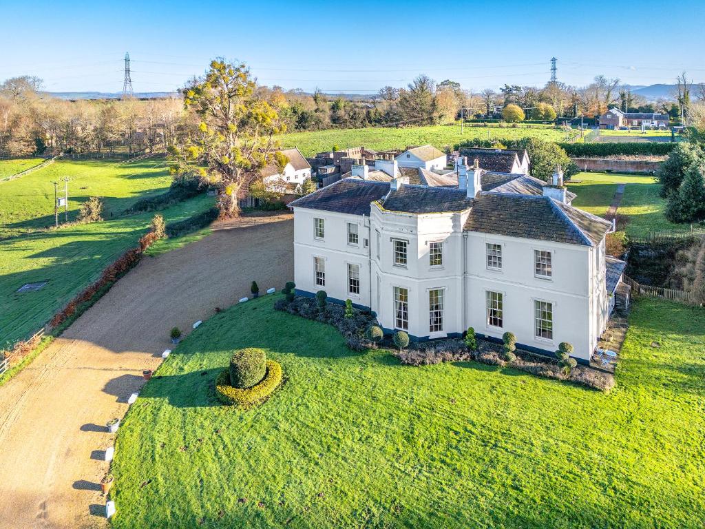 an aerial view of a white house on a green field at Pengethley Manor - Uk39045 in Peterstow