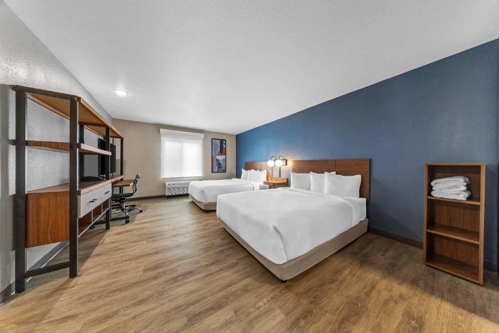 a hotel room with two beds and a tv at Everhome Suites Ontario Airport in Ontario