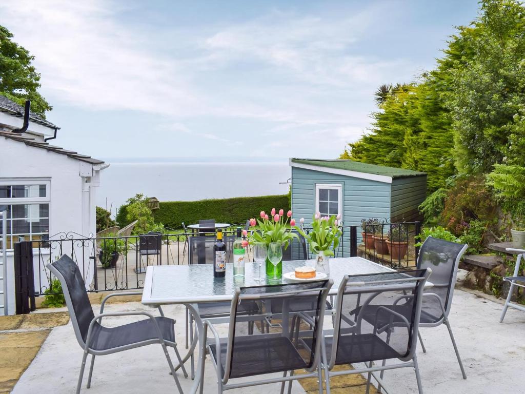 a table and chairs on a patio with a house at Seacliffe in Kildonan