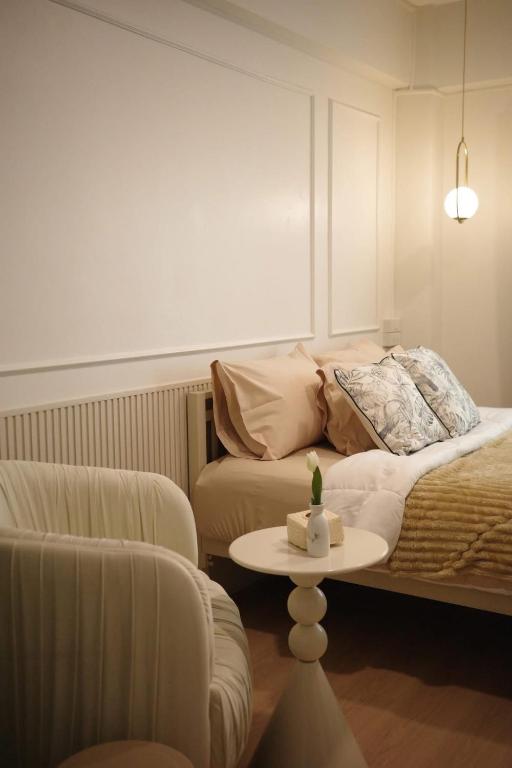 a room with a bed and a table and a couch at Mari Home in Bangsaen