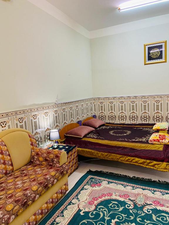 a bedroom with two beds and a couch at Heritage House in Nizwa