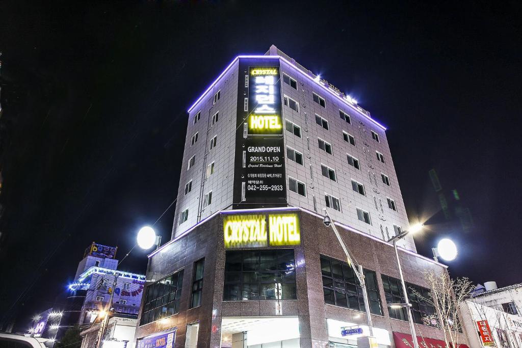 um edifício alto com um letreiro de néon em cima em Crystal Residence Hotel em Daejeon
