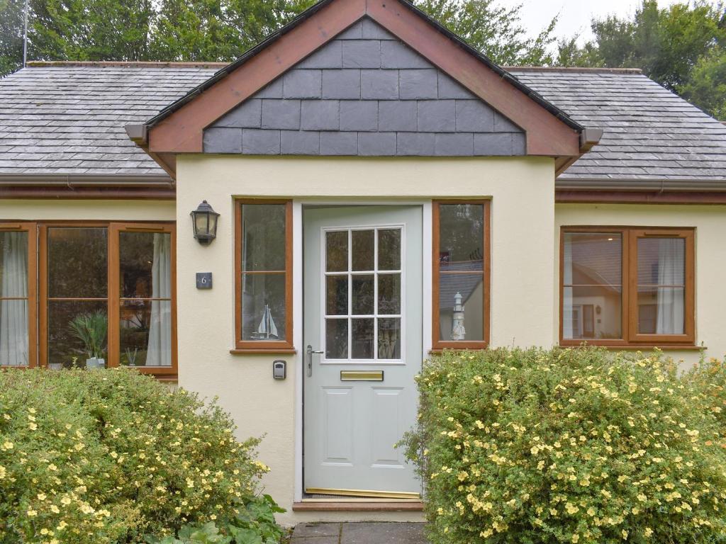 a small house with a white door at Endless Summer Cottage in Camelford