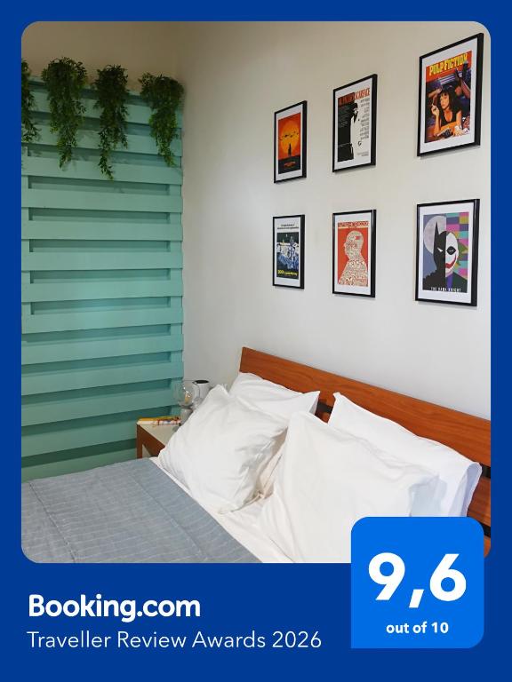 a bedroom with a bed and pictures on the wall at Under the Palms in Nicosia