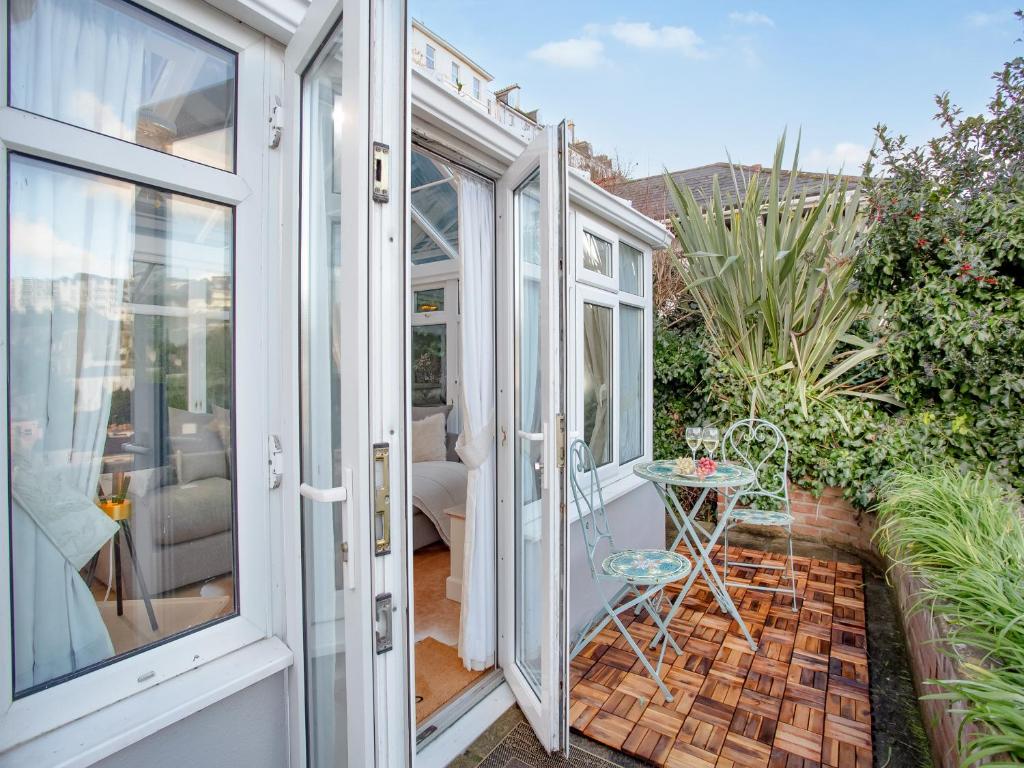 a conservatory with a glass door and a table on a patio at Rock House Apartment in Torquay