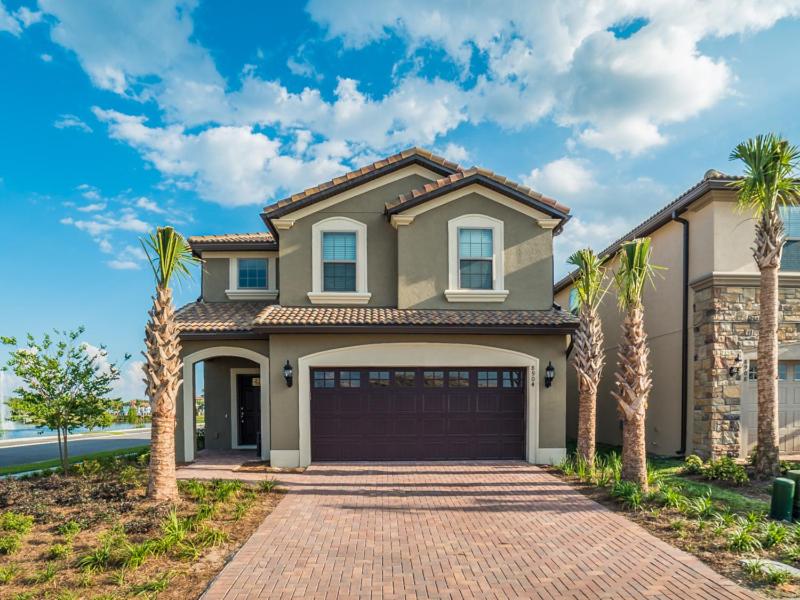 une maison avec des palmiers devant elle dans l'établissement Rhodes Villa 8904, à Kissimmee