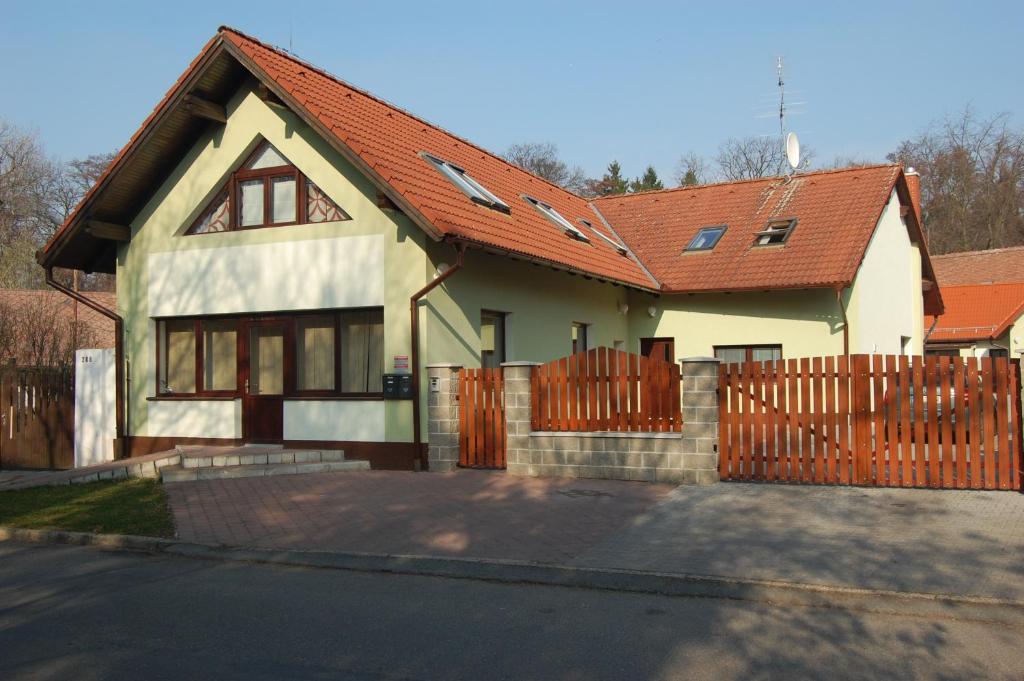 a house with a red roof and a fence at Apartmany U Stareho Labe in Nymburk