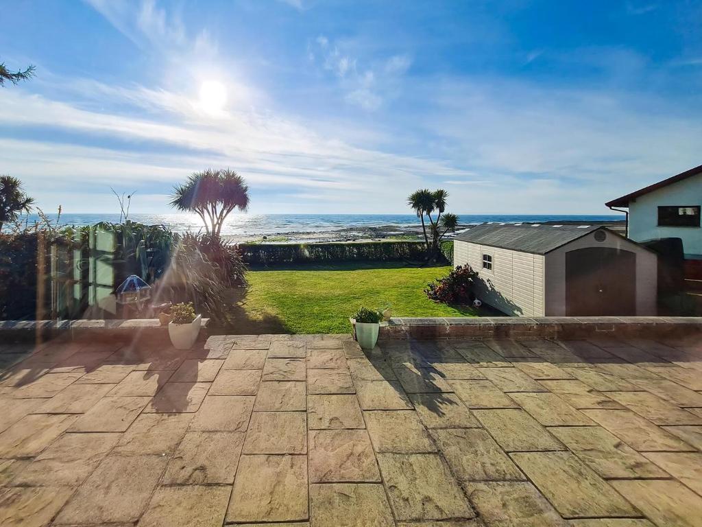 a brick patio with a view of the ocean at Southcroft Lodge in Whiting Bay