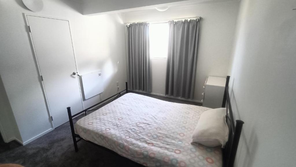 a small bedroom with a bed and a window at Suthar's Home in Wellington