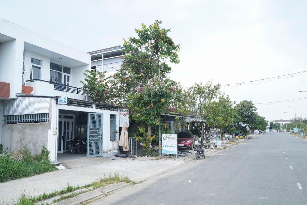 an empty street next to a white building with a shop at Tâm An Hotel 2 in Nhơn Trạch