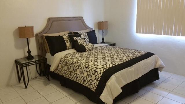 een slaapkamer met een groot bed en 2 lampen bij Beautiful 2 bedroom 1 bath in Tamuning