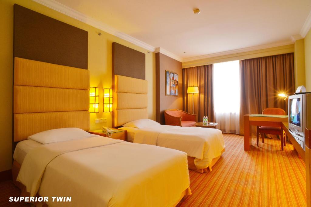 Postel nebo postele na pokoji v ubytování Dynasty Hotel Miri
