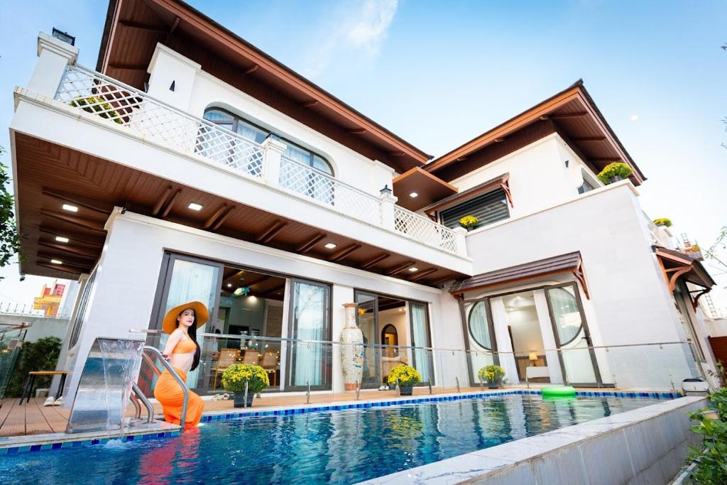 a house with a swimming pool in front of it at B'Villa Luxury in Dong Hoi
