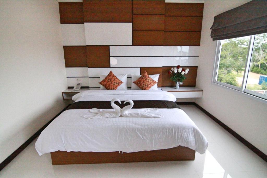 a bedroom with a bed with two swans on it at TTT Hotel in Hat Yai