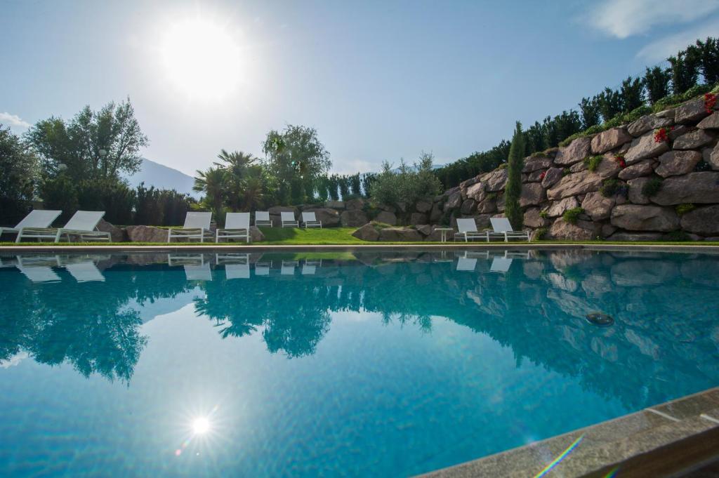 a swimming pool with chairs and a rock wall at Hidalgo Suites in Postal