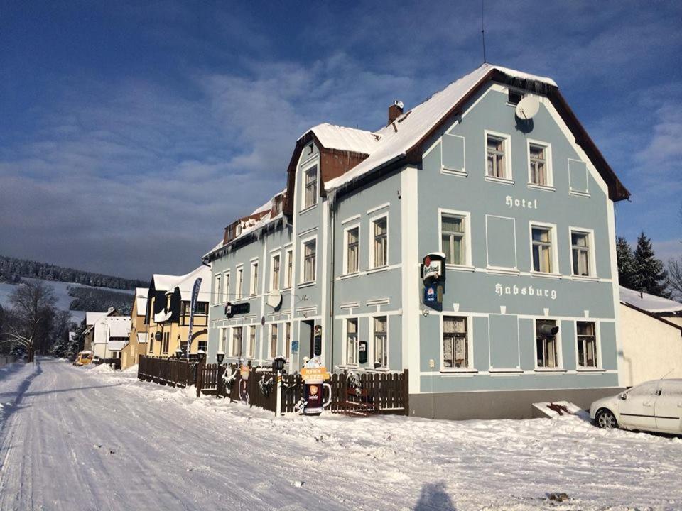 a large building on a snow covered street at Hotel Habsburg in České Hamry