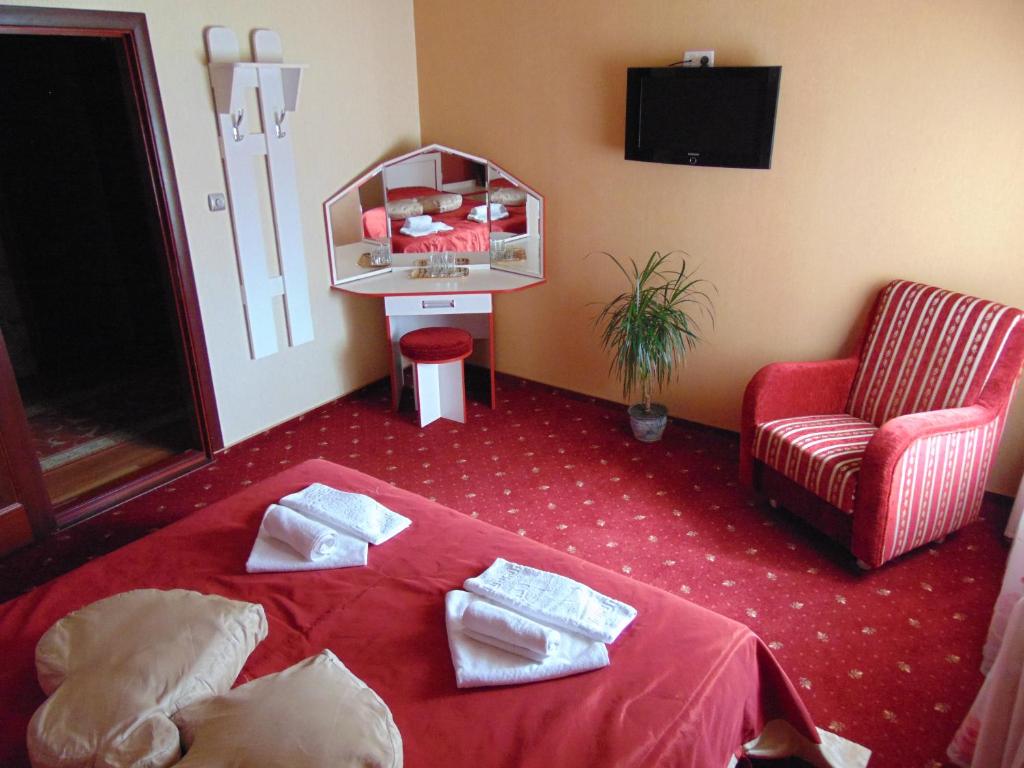 a room with a table, chairs, and a rug at Hotel Serpanok in Tyachiv