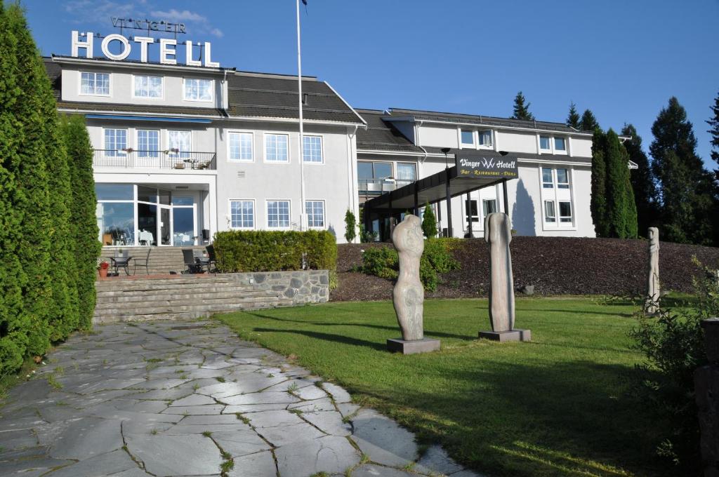 a hotel with a statue in front of it at Vinger Hotell in Kongsvinger