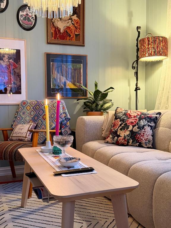 a living room with a couch and a table with a candle at Cabin in Tappeluft in Alta