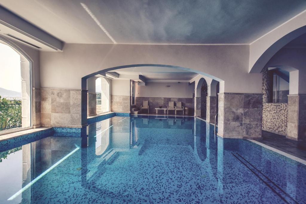 a swimming pool in a building with an archway at Hotel Azimut in Sveti Stefan