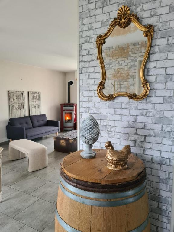 a living room with a mirror on a brick wall at Les malices d'Ulysse in Péronne