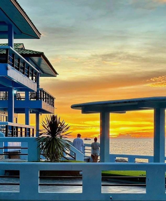 two people standing outside of a building at sunset at Ocean View Resort in Ko Tao
