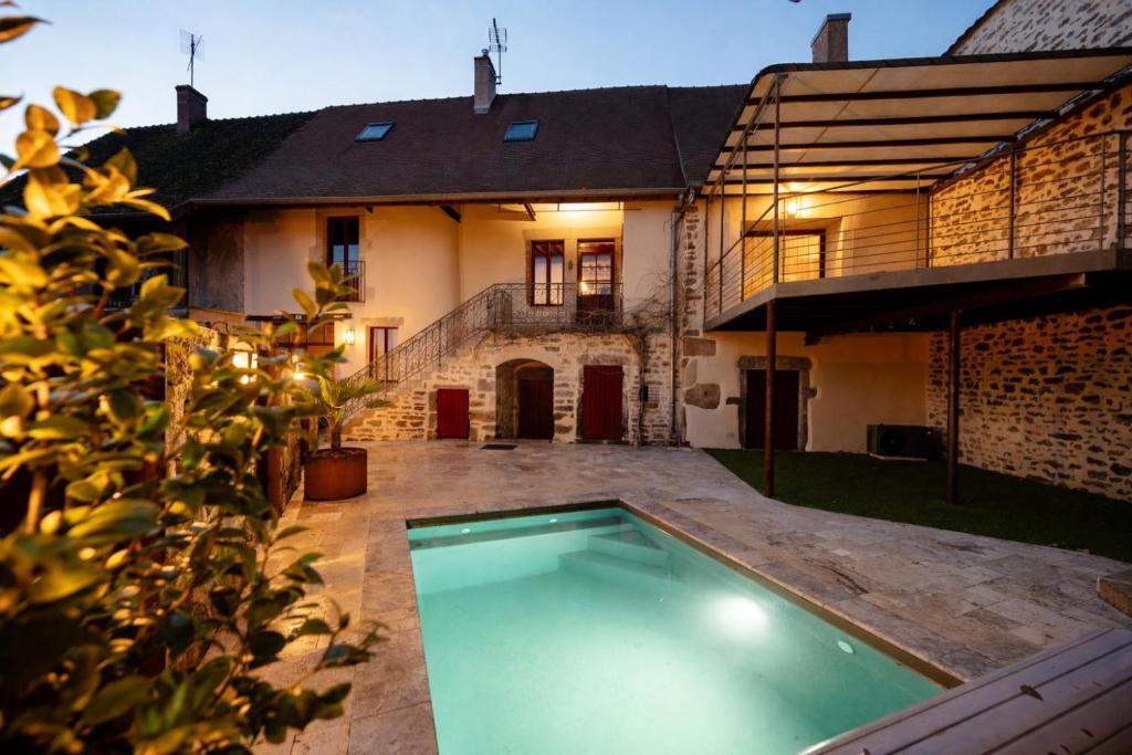 an empty swimming pool in front of a house at Sur Les Roches in Dracy-lès-Couches