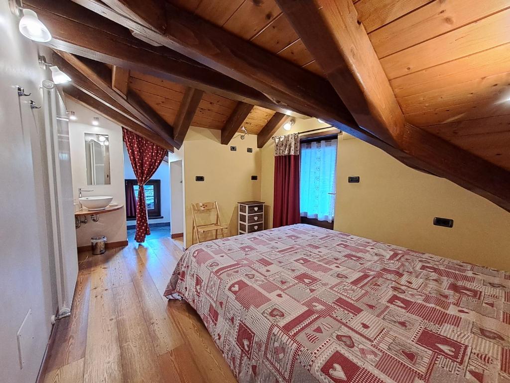 a bedroom with a bed and a wooden ceiling at Maison Leveque in Brusson