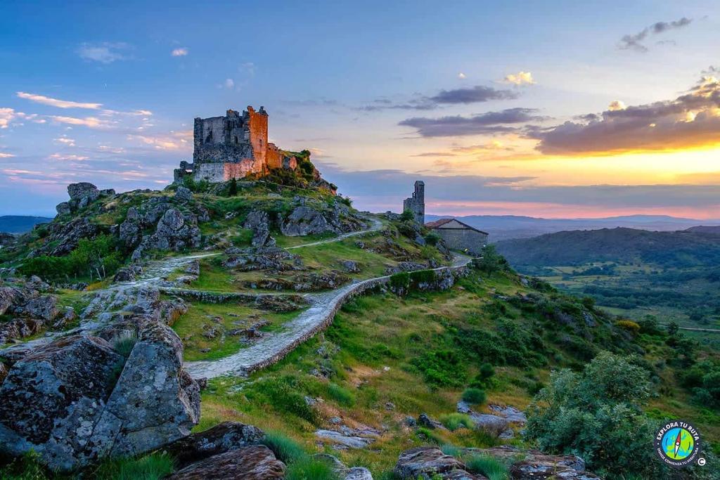 a castle on the top of a hill with a road at A Bolota, Casa rural in Trevejo