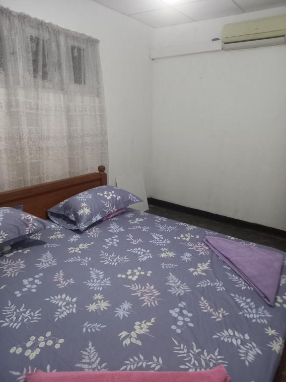 a bedroom with a bed with a blue comforter and pillows at Volunteer lanka in Padukka