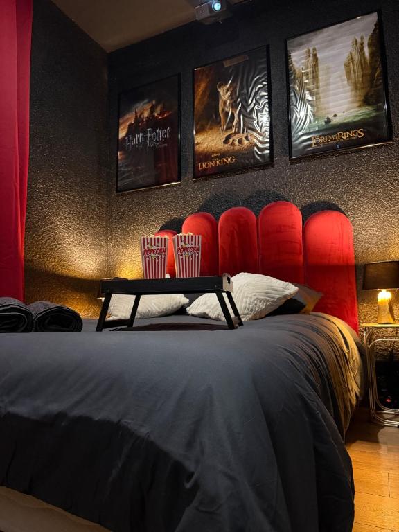 a bedroom with a bed with red chairs and posters at Ciné Room Home Cinema Netflix Experience in Lunel