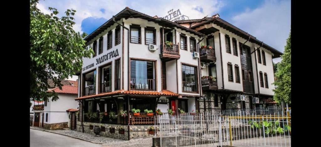 a large white building with a fence in front of it at Златоград in Zlatograd