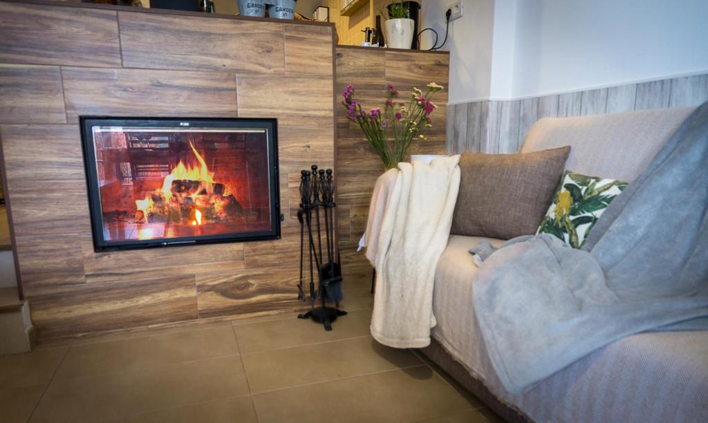 a living room with a fireplace and a couch at El Barro Colorao in Segura de León