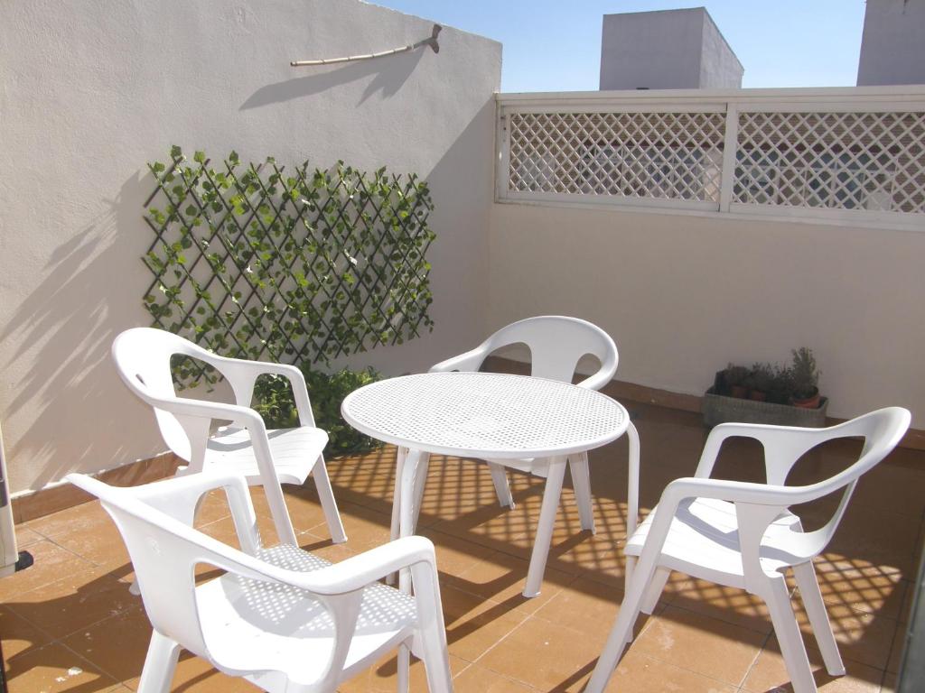 サラゴサにあるÁtico con terraza en la Jotaのパティオ(白いテーブル、椅子付)