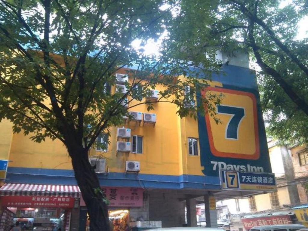 um grande edifício amarelo com um sinal nele em 7Days Inn Guangzhou Beijing Road Subway Station em Guangzhou