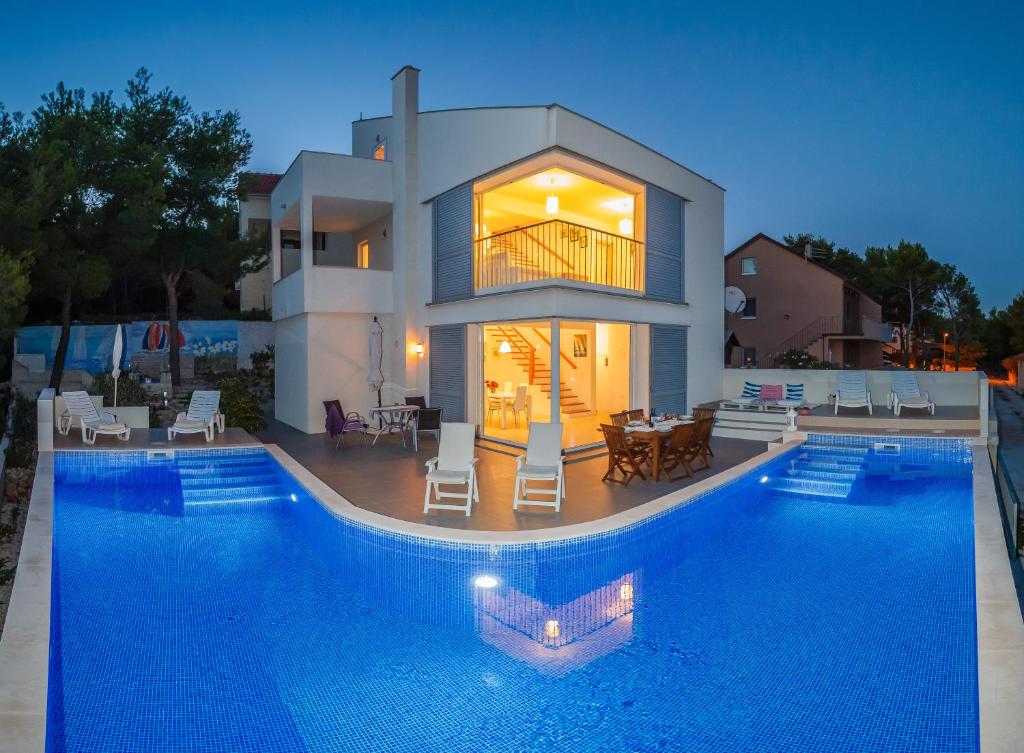ein großes Haus mit Pool davor in der Unterkunft Villa Casabianca in Milna