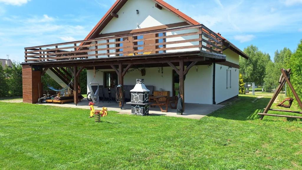 a house with a gambrel roof on top of a yard at Dom letniskowy Sieraków in Sieraków