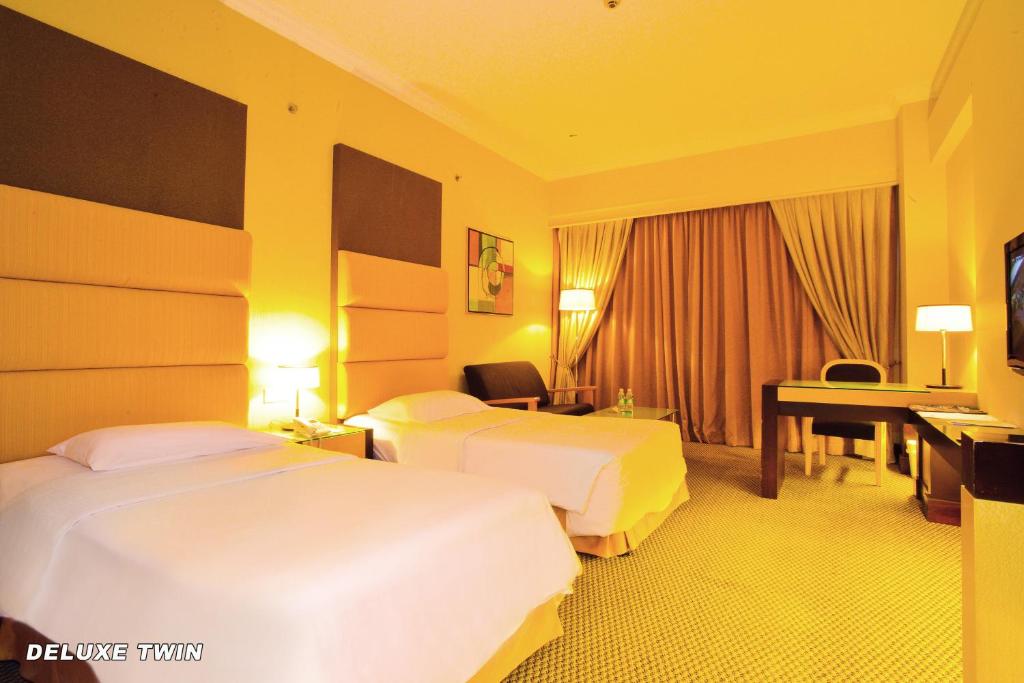 Postel nebo postele na pokoji v ubytování Dynasty Hotel Miri