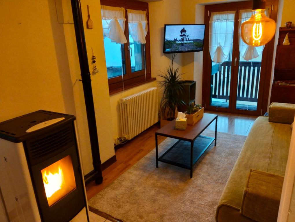 a living room with a fireplace and a tv at La Cloche in Valtournenche