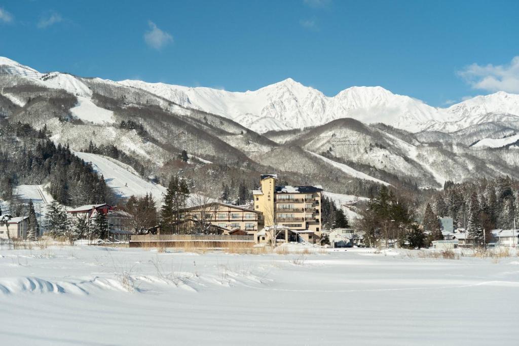 ein Gebäude inmitten eines schneebedeckten Berges in der Unterkunft Hotel Goryukan in Hakuba