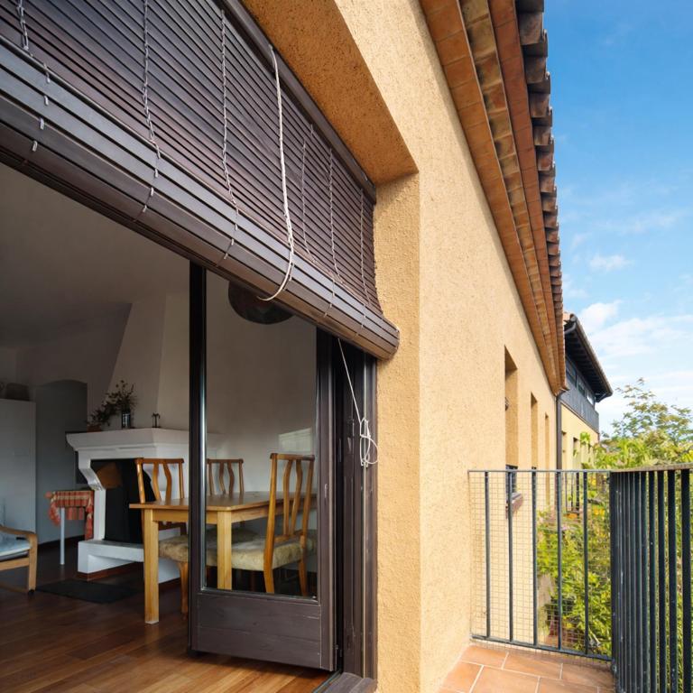 a glass door leading to a dining room with a table at Apartament amb llar de foc - Golfes Cal Gravat in Montsonis