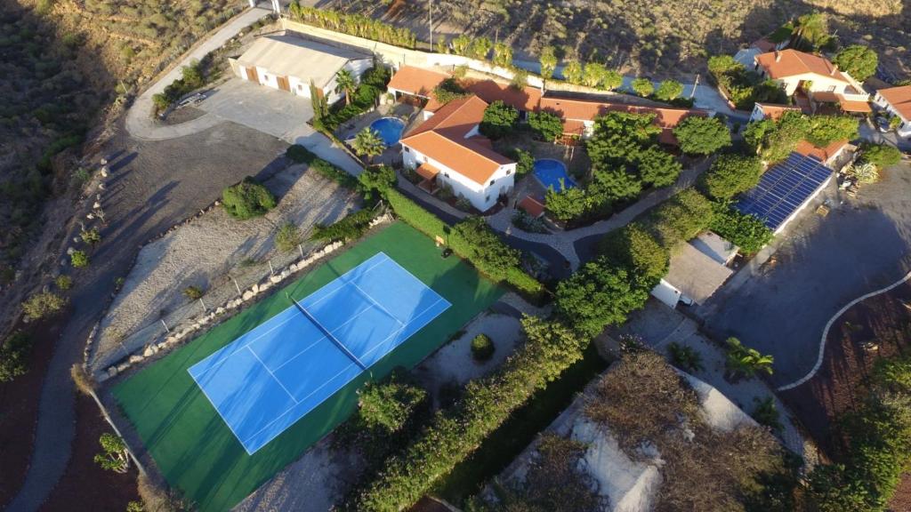 an overhead view of a house with a large blue tennis court at Casa granero 2 in El Río