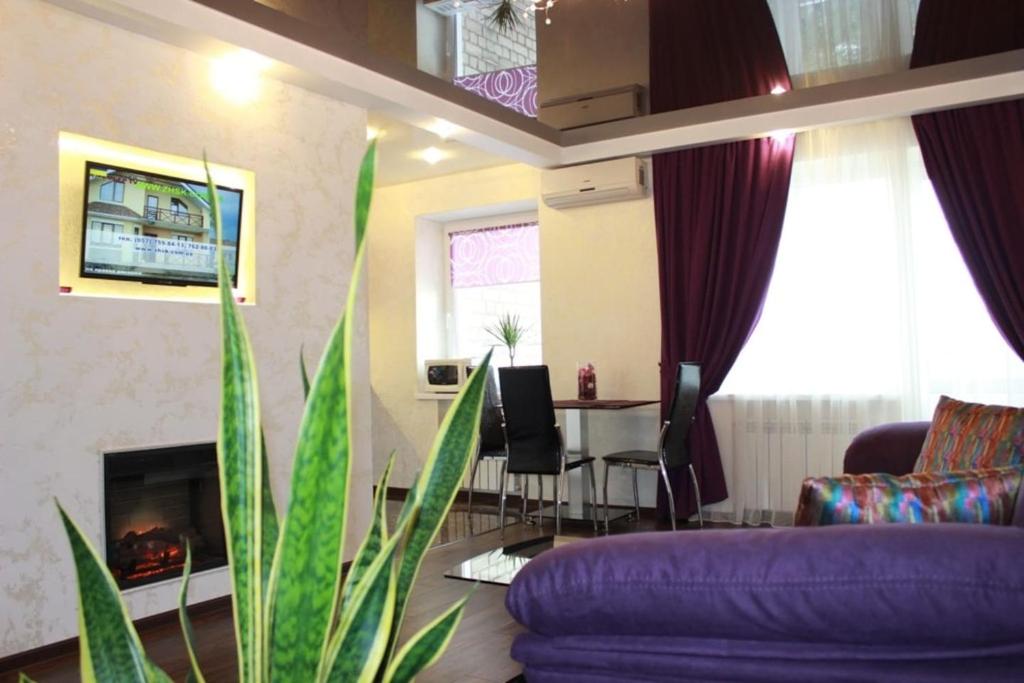 a living room with a purple couch and a table at Kharkiv Center Apartment on Hoholya Str, Poetry square in Kharkiv