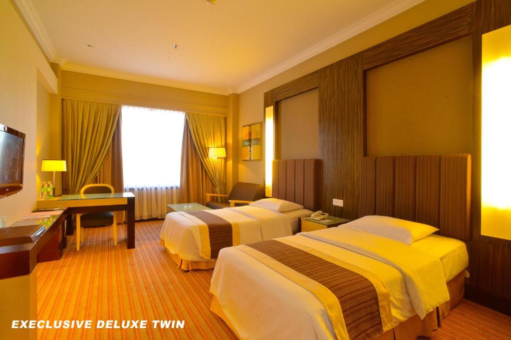 Postel nebo postele na pokoji v ubytování Dynasty Hotel Miri