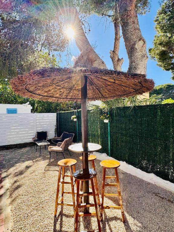 a table with two stools and an umbrella at Les cases del vent II in Calafat