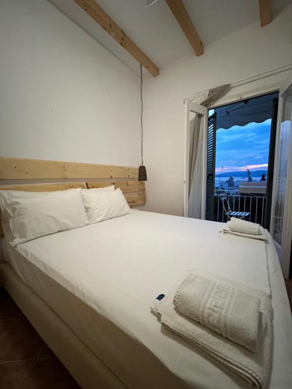 a bedroom with a large white bed with a window at SEA HOME Accommodation in Loutraki