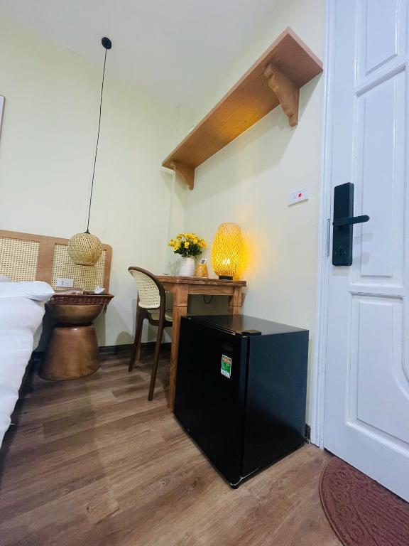 a bedroom with a bed and a desk with a table at Silk Homestay LVC Central in Hanoi
